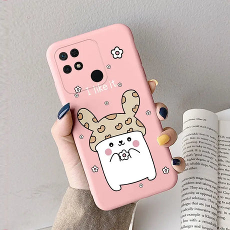 a woman holding a pink phone case with a cartoon dog on it