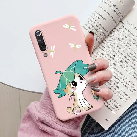 a woman holding a pink phone case with a cartoon character on it