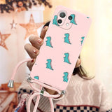 a girl holding a pink phone case with a green dinosaur on it