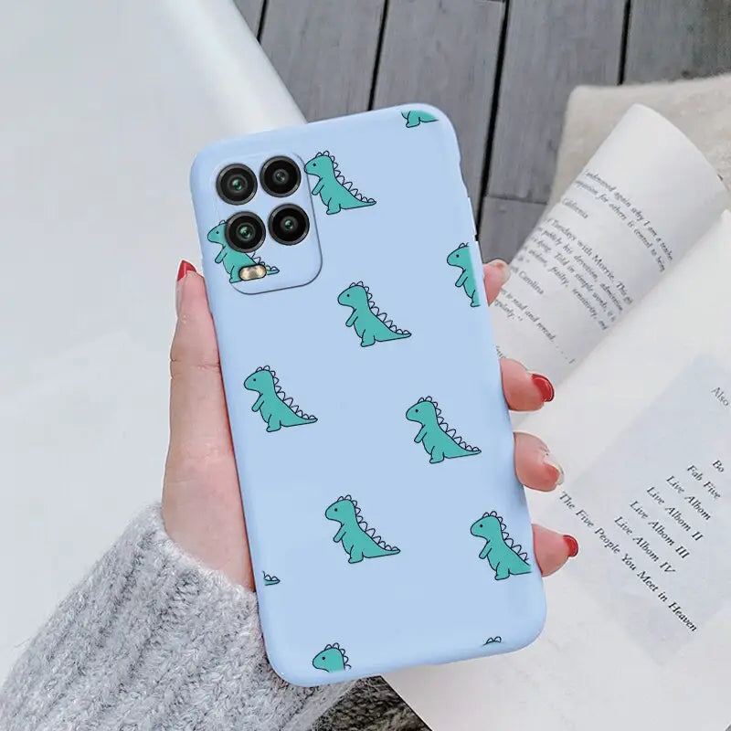 a woman holding a phone case with a green dinosaur pattern