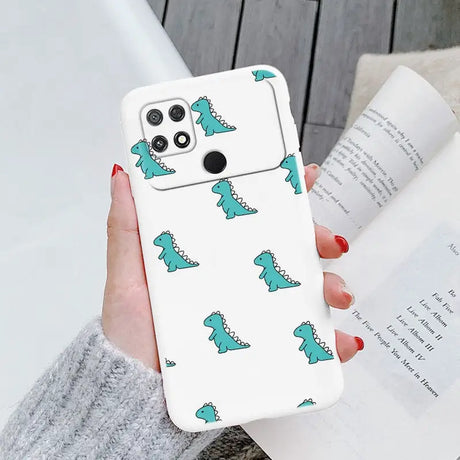 a woman holding a phone case with a green dinosaur pattern