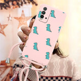 a woman holding a pink phone case with a green dinosaur print