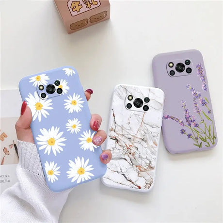 a woman holding a phone case with flowers on it