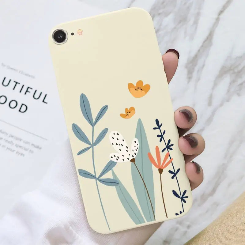 a hand holding a phone case with a flower design