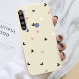 a hand holding a phone case with hearts on it