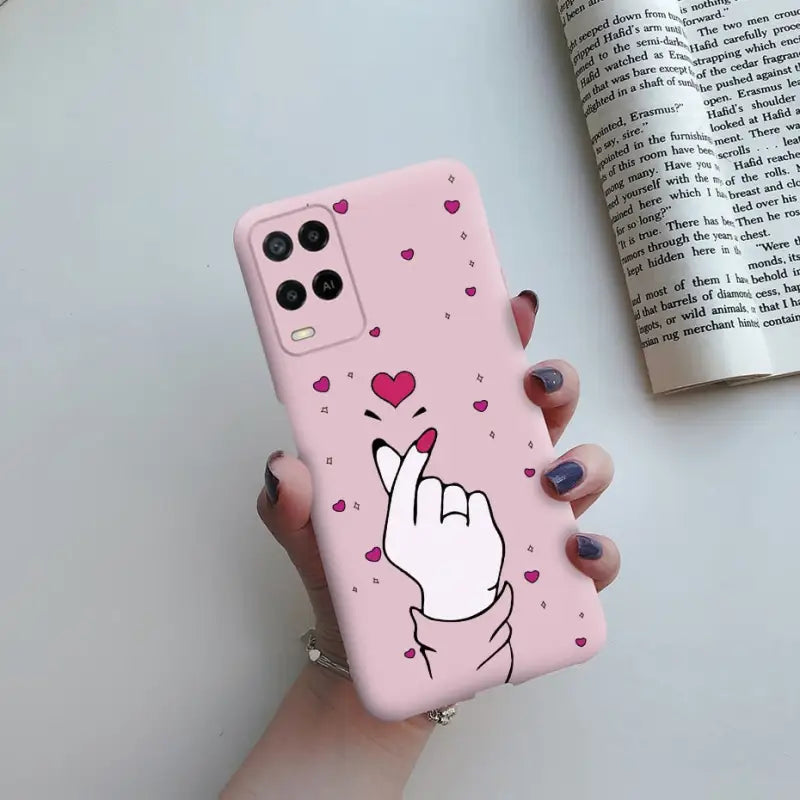 a pink phone case with a heart and a hand gesture