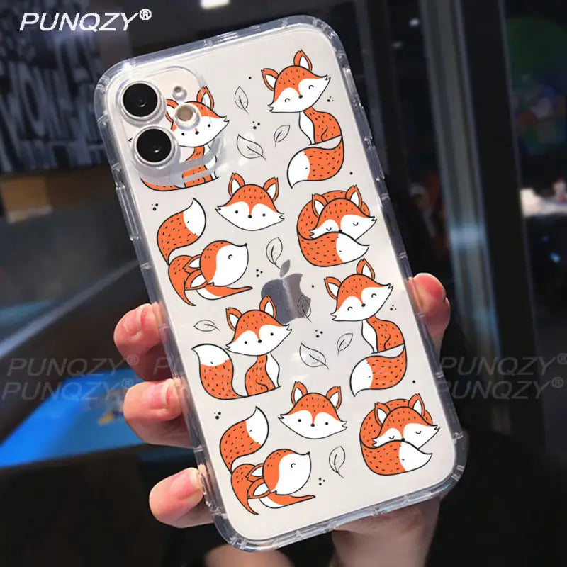 a hand holding a phone case with foxes on it