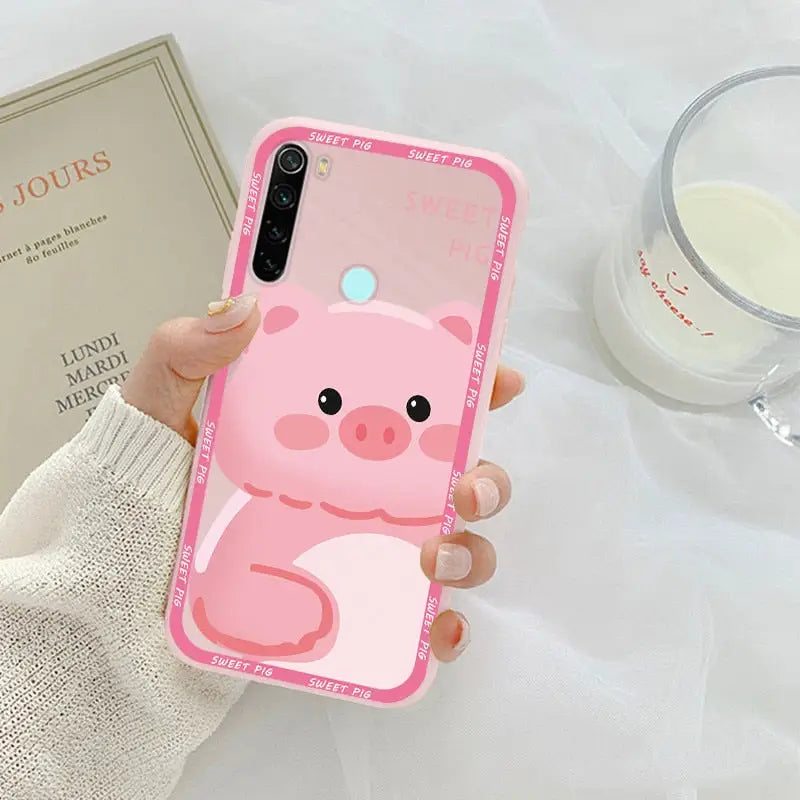 a woman holding a pink pig phone case