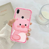 a woman holding a pink phone case with a pig face