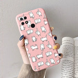 a woman holding a pink phone case with white cats on it