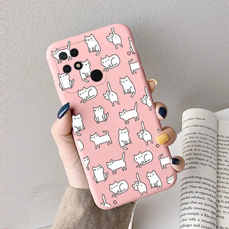 a woman holding a pink phone case with white cats on it