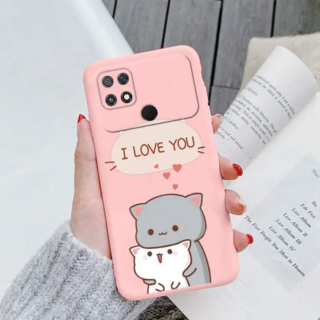 a woman holding a pink phone case with a cartoon cat