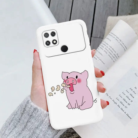 a woman holding a phone case with a pig on it