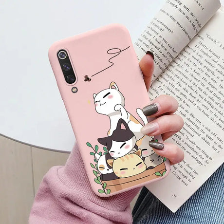 a woman holding a phone case with a cat on it