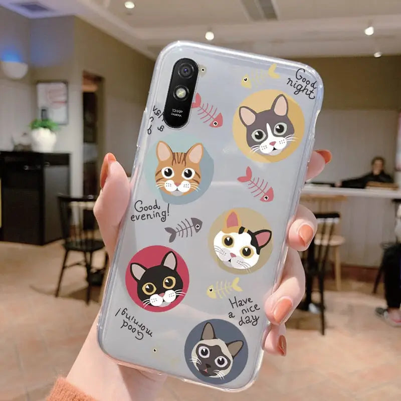 a woman holding up a phone case with cats on it