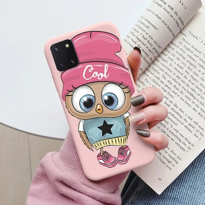someone holding a pink phone case with a cartoon owl on it