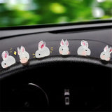 a car dashboard with a bunch of white rabbits on the dashboard