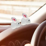a pair of white rabbit ears on a car dashboard