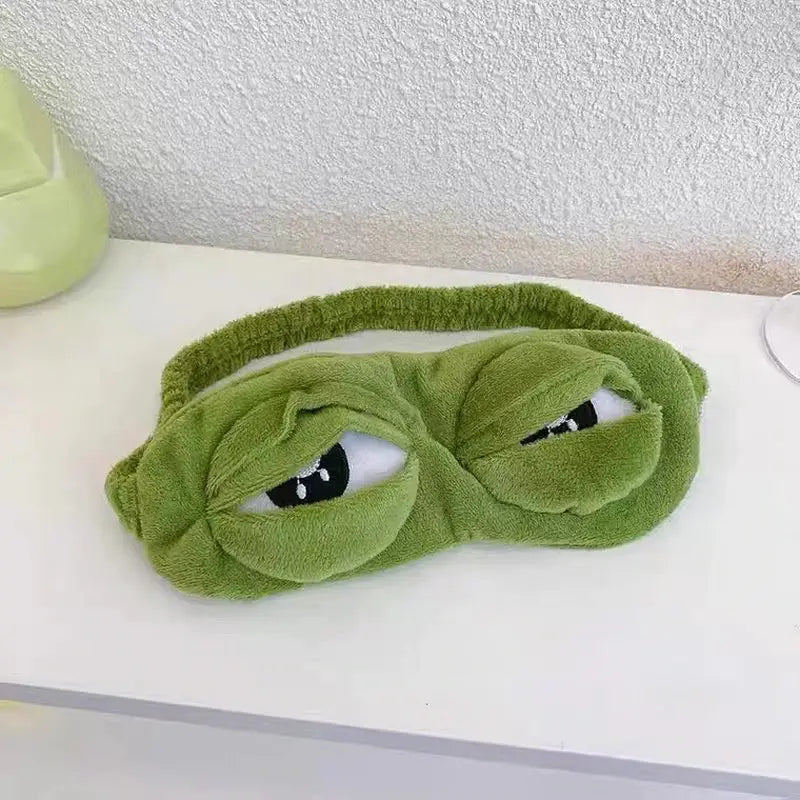 a green eye mask with a pair of eye masks on it