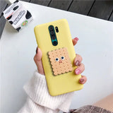 a woman holding a yellow phone case with a cookie on it