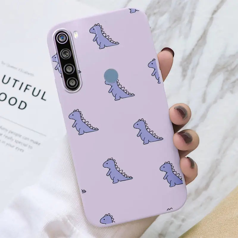 a woman holding a purple phone case with a pattern of blue cats on it