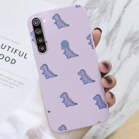 a woman holding a purple phone case with a pattern of blue cats on it