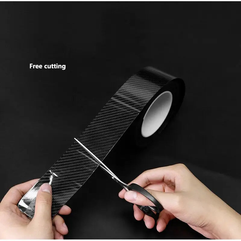 someone cutting a piece of black carbon fiber with scissors