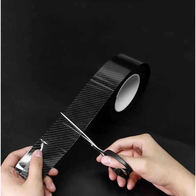 a hand holding a black tape with a black handle