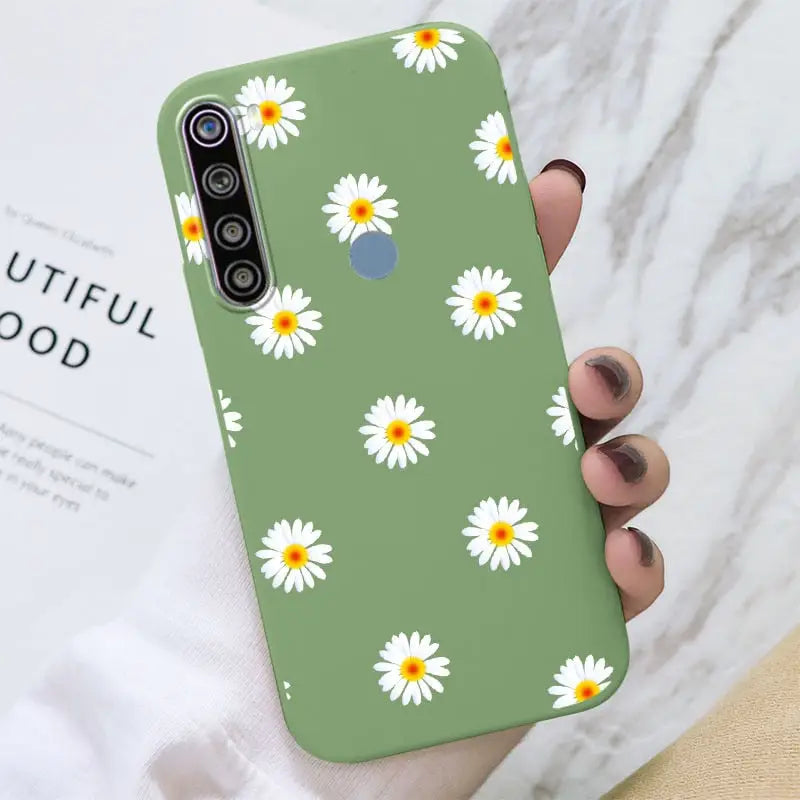 a close up of a person holding a green phone case with daisies on it