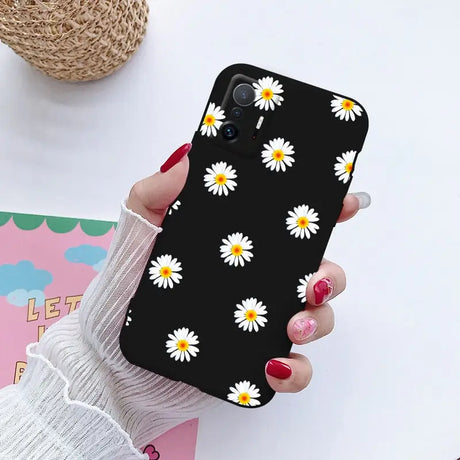 a close up of a person holding a phone with a flower pattern on it