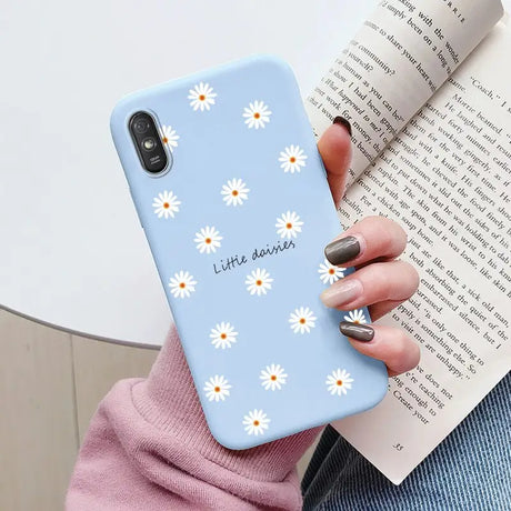 a close up of a person holding a phone case with daisies on it