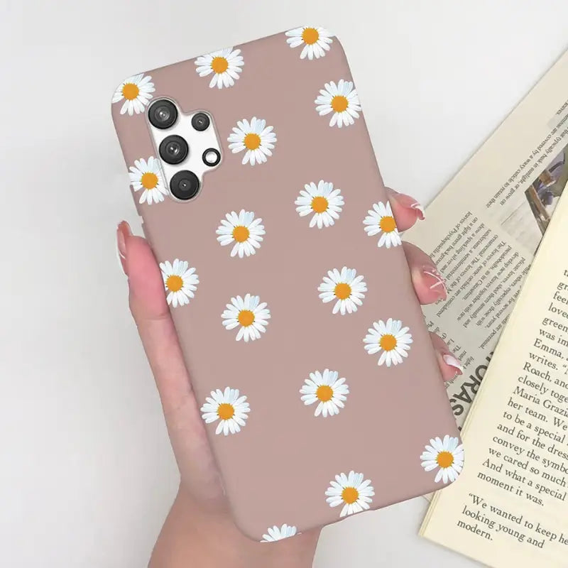 someone holding a phone case with a daisy pattern on it