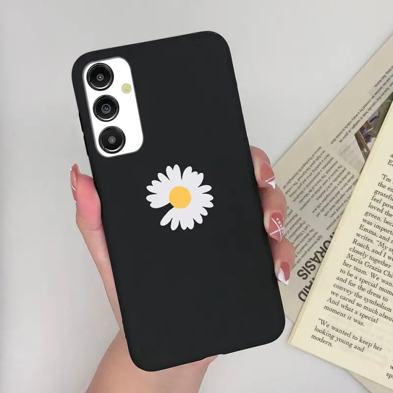 a woman holding a phone case with a daisy on it