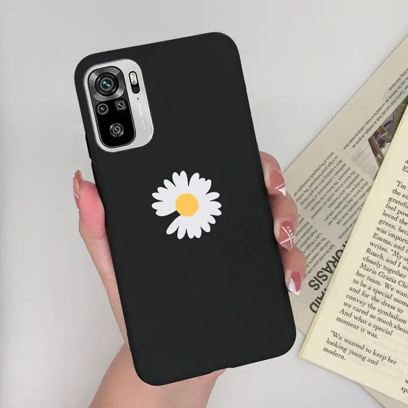 a woman holding a phone case with a daisy on it