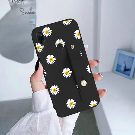 someone holding a phone case with a daisy pattern on it