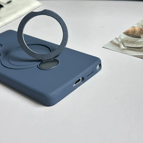 A dark blue phone case with a silver, circular, magnetic ring holder.