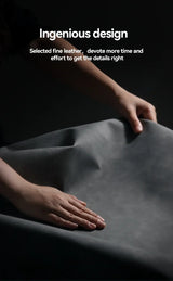 A dark gray, flexible material being stretched or manipulated by hands.