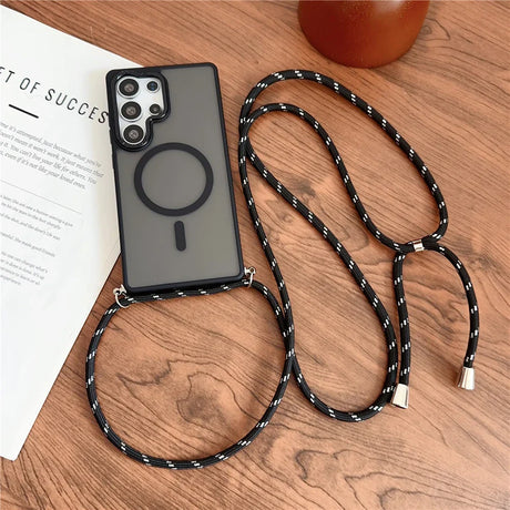 A dark gray phone case with a magnetic ring and a black and white patterned lanyard.