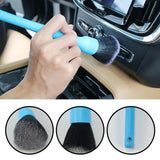 a person using a brush to clean the interior of a car