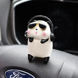 a car dashboard with a toy penguin wearing headphones