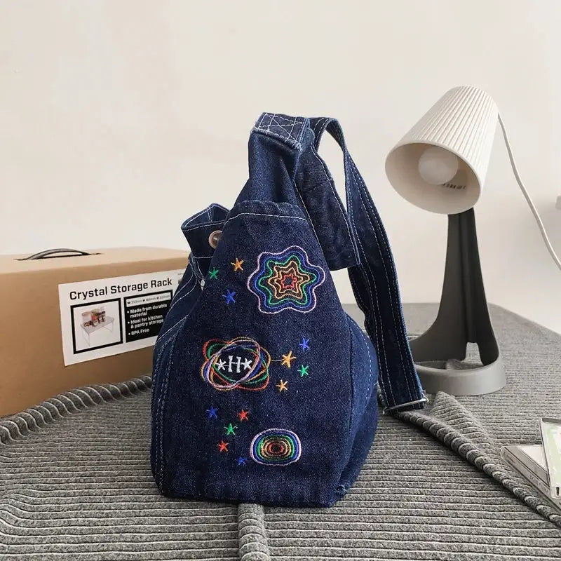 a denim backpack with embroidered patches on it