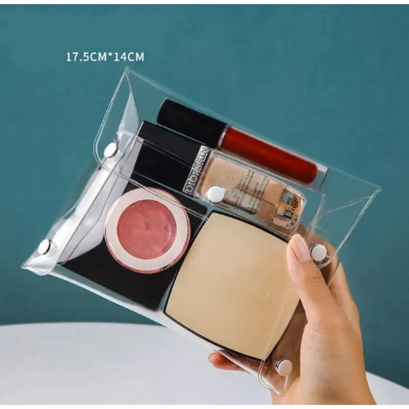 a person holding a clear box with various makeup products