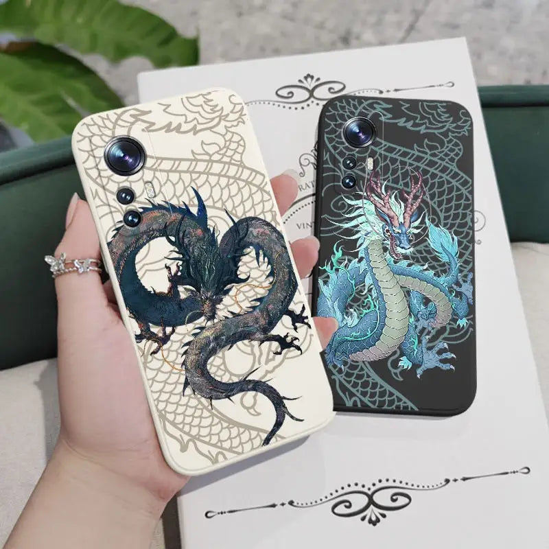 a hand holding a phone case with two dragons on it