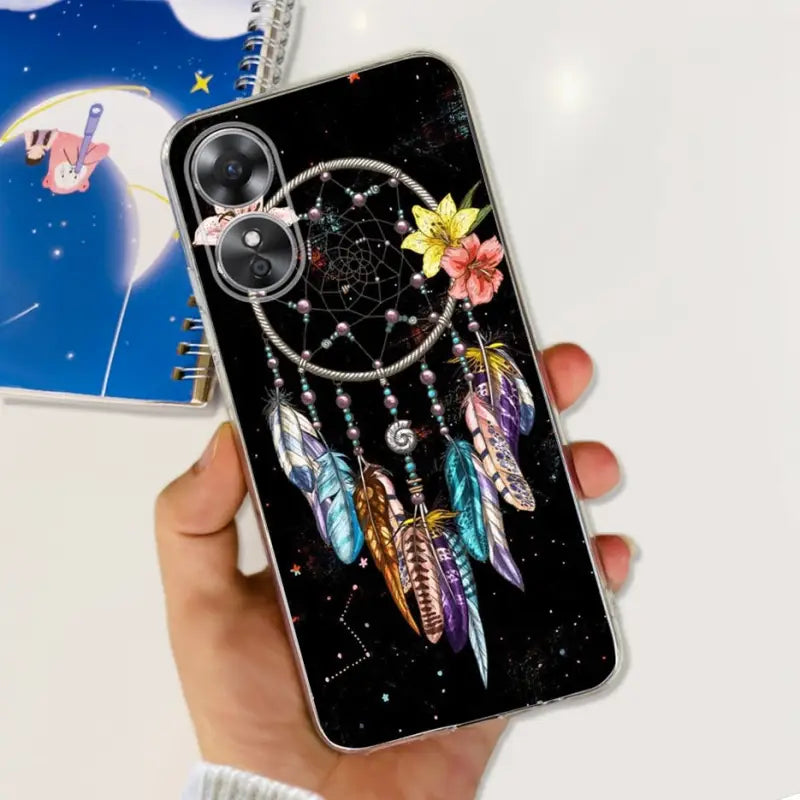 a hand holding a phone case with a dream catcher