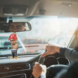 a man in a car with a toy on the dashboard