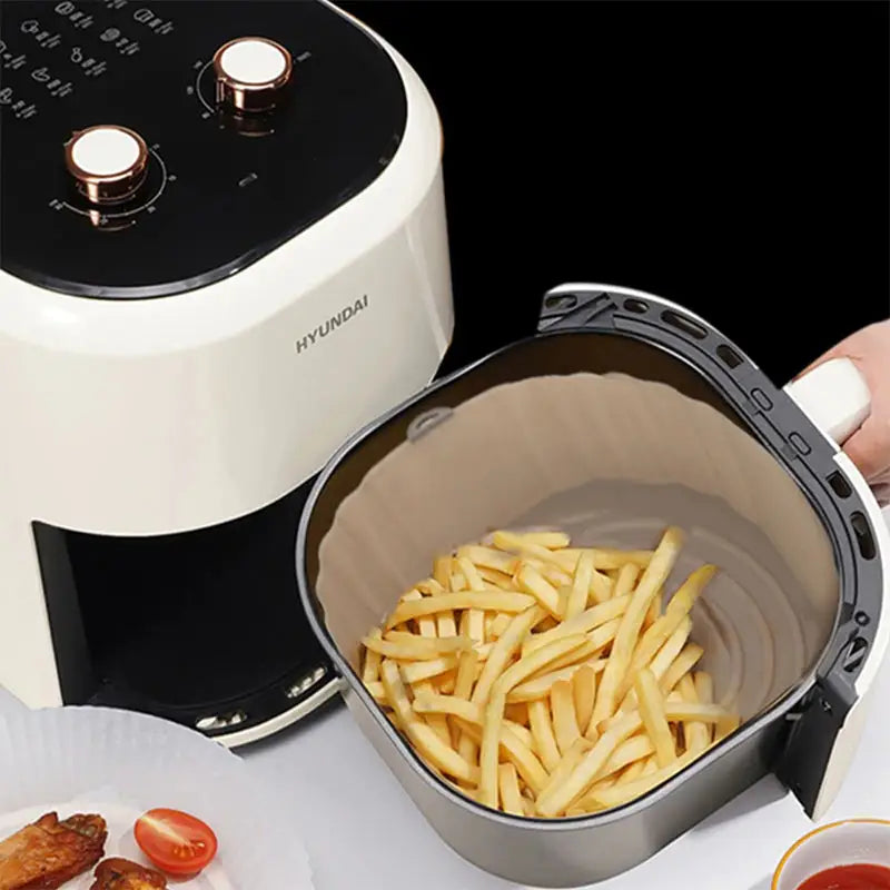 a person is putting french fries into a fryer