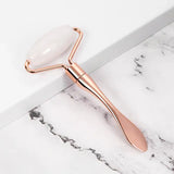 a rose gold spoon with a white marble handle