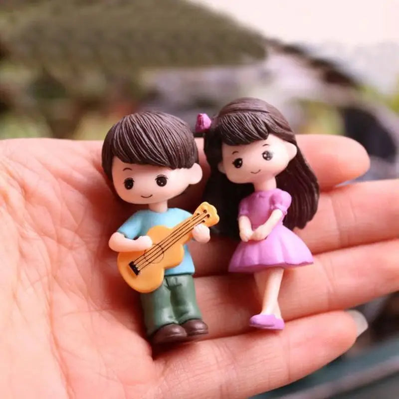 a person holding a miniature guitar and a miniature girl