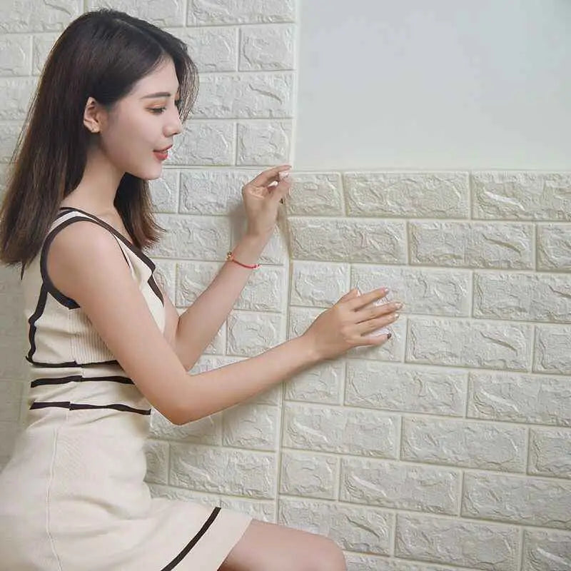 a woman sitting on a wall with her hand on the wall