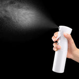 spray bottle in the hand on a black background